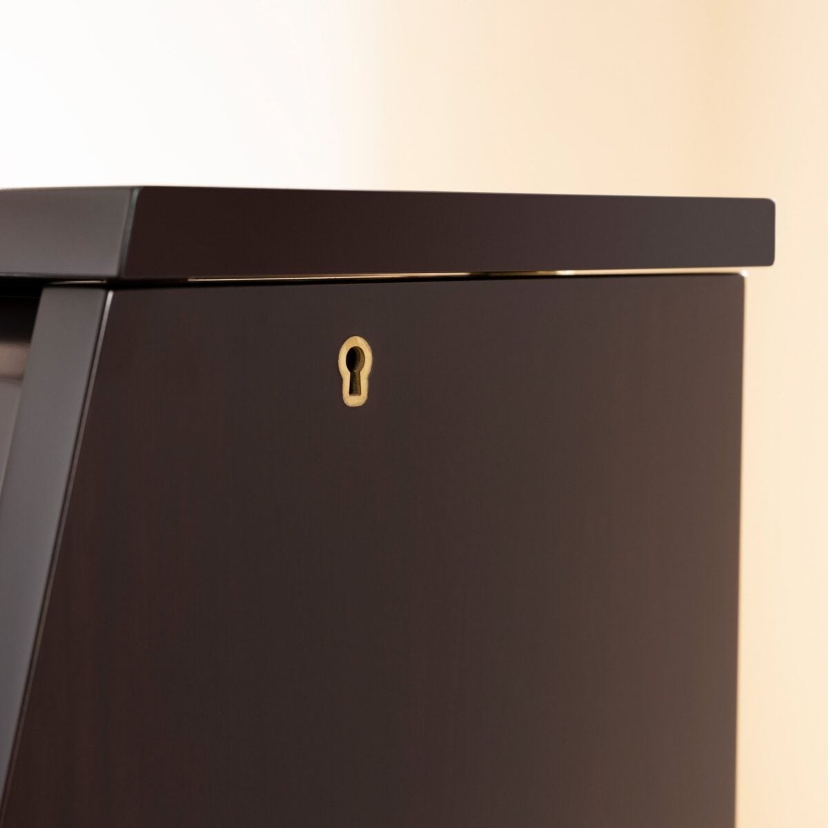 Mahogany polish piano lid detail with keyhole at Classic Pianos. Durable wood finish emphasizes elegance.