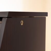Mahogany polish piano lid detail with keyhole at Classic Pianos. Durable wood finish emphasizes elegance.