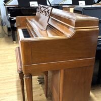 Vintage polished upright piano with rich mahogany finish, featuring classic detailing and a comfortable bench. Ideal for homes.