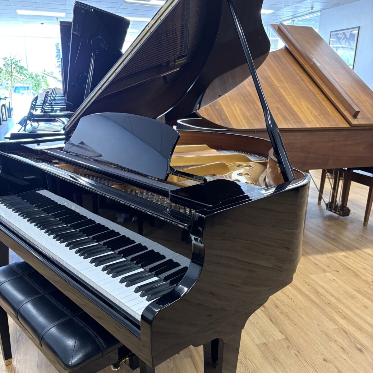 Glossy black grand piano with polished finish, featuring a responsive keyboard and premium craftsmanship at Classic Pianos Reno.