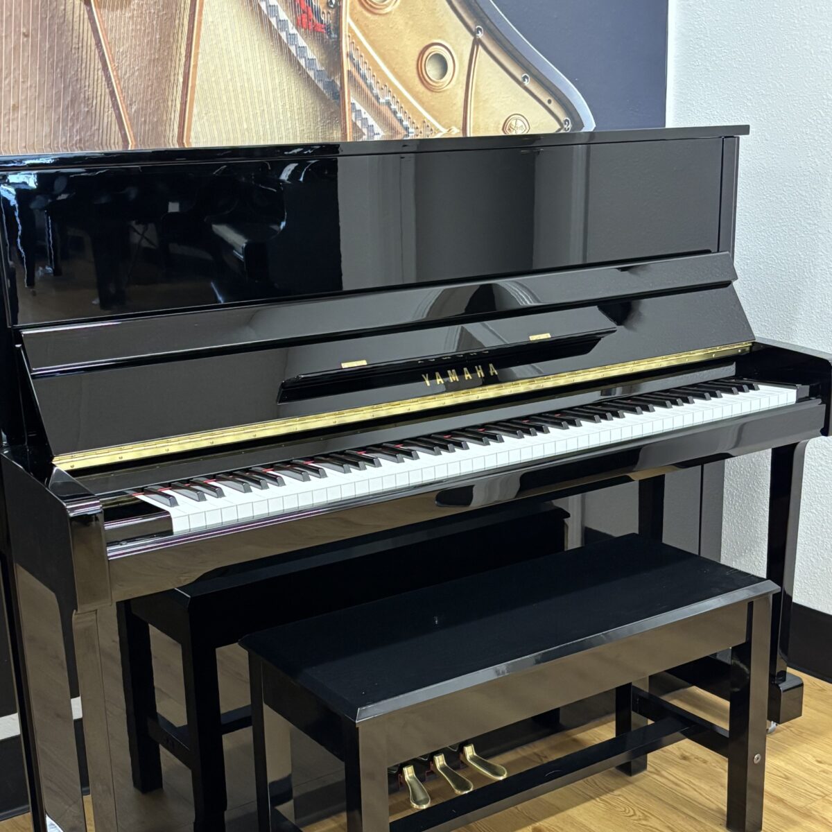 Yamaha upright piano in sleek black finish with polished keys and matching bench, ideal for any music enthusiast.