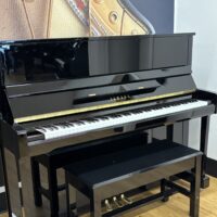 Yamaha upright piano in sleek black finish with polished keys and matching bench, ideal for any music enthusiast.