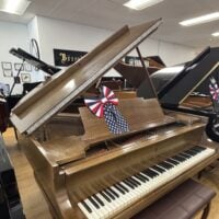 Vintage grand piano with polished mahogany finish, showcasing an elegant design and meticulous craftsmanship.