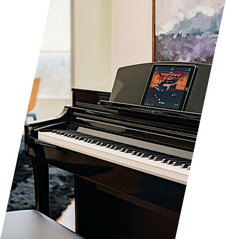 Digital piano with sleek black finish in a modern showroom setting.